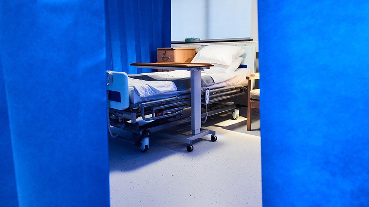 Photograph of an empty hospital bed.