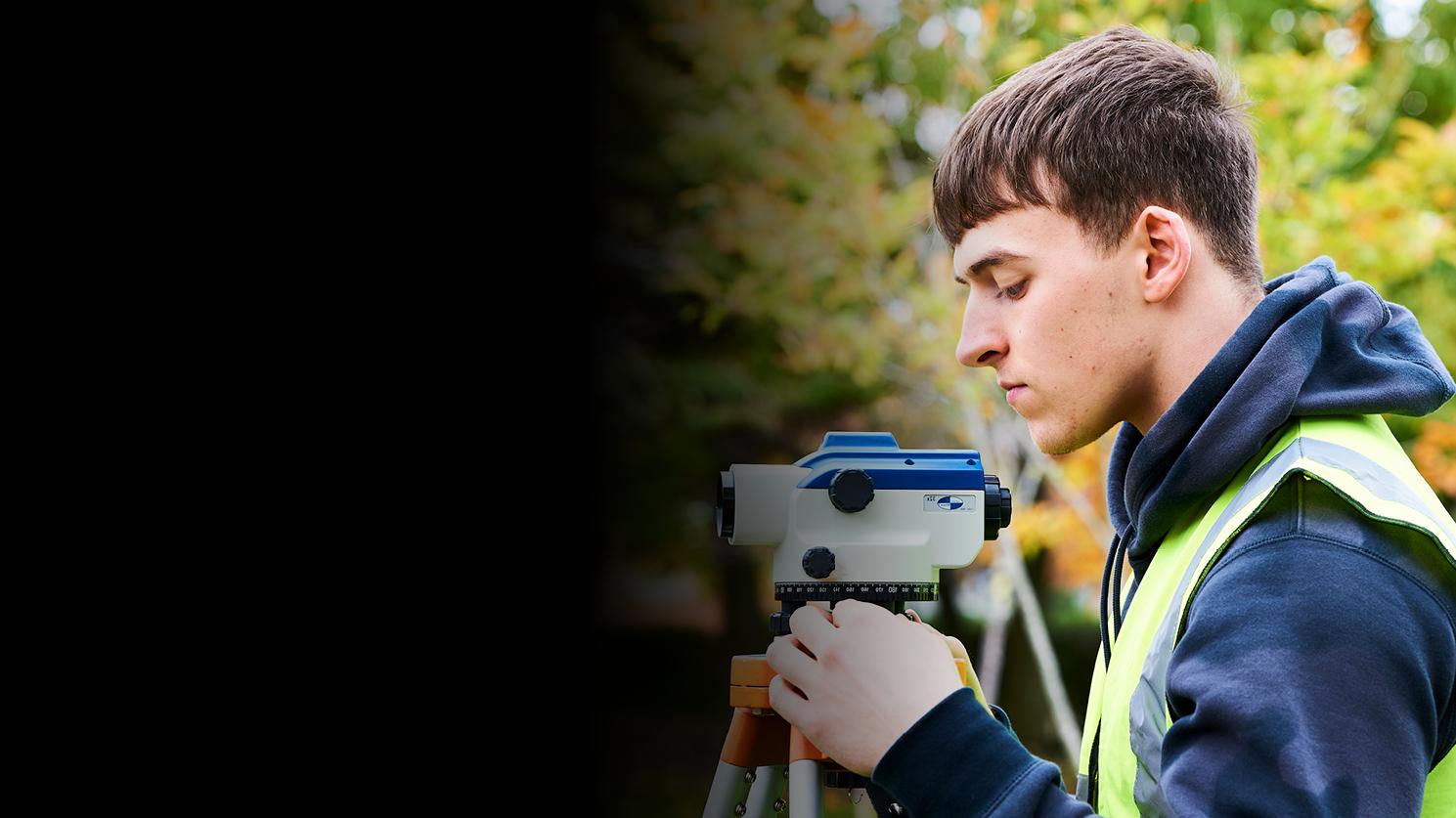Young person with surveying equipment