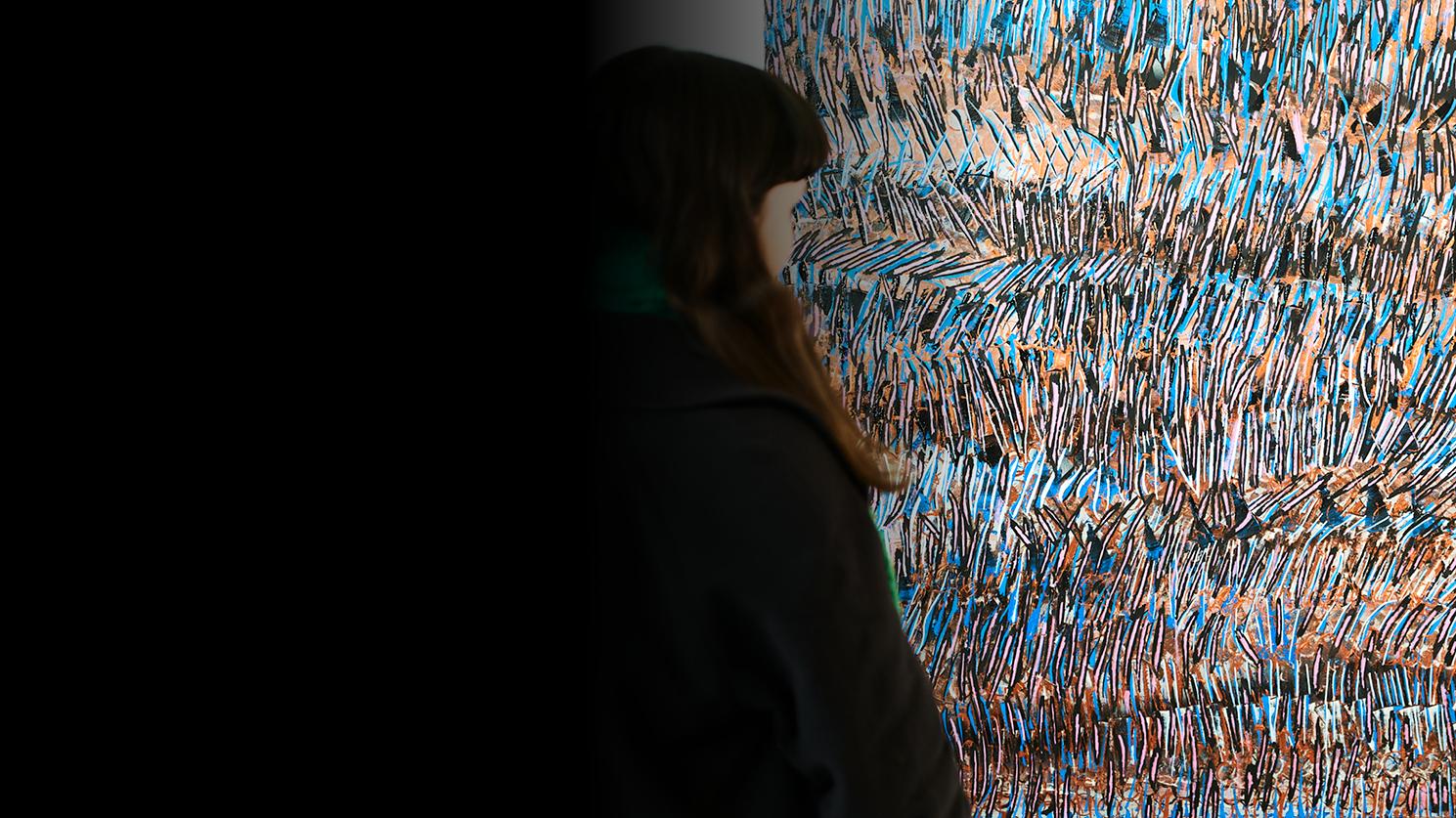 Young woman looking at an abstract art installation on the wall